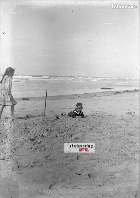 Une petite fille jouant dans le sable avec un camion jouet photo