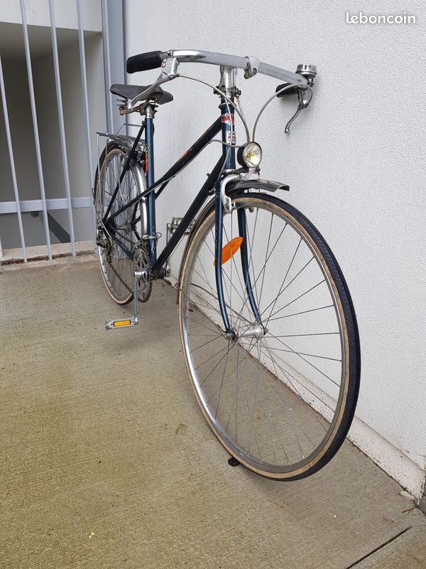 Vélo de ville vintage à l'ancienne bleu avec garde boue et porte bagage