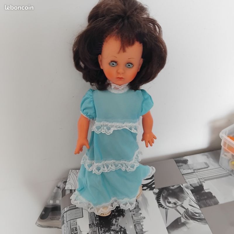 Jolie poupée aux cheveux bouclés roux, aux yeux bleus et à la robe