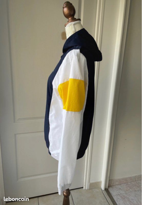 Veste coupe vent à capuche Lacoste couleur bleue blanche et jaune