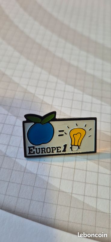 Pin's Europe 1 pomme bleue et ampoule 💡 jaune (image 1)