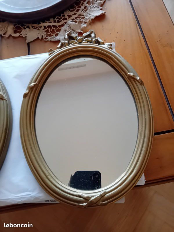 Paire de petits miroirs ovales dans des encadrements en bois sculpté et