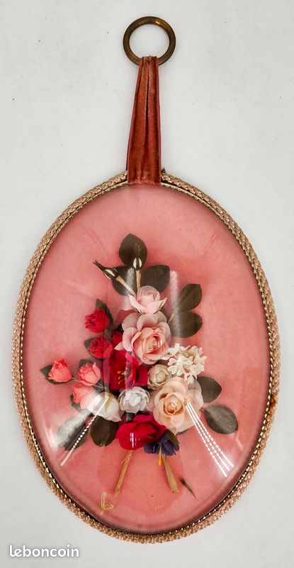 Cadre médaillon ovale vintage en verre bombé, orné d'un bouquet de fausses roses et de fleurs en tissu sur fond rose (image 1)