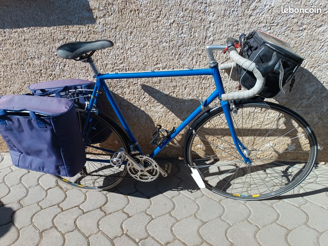 Vélo de randonneur sur un passage pavé. Place Notre-Dame. Cluny. Saône