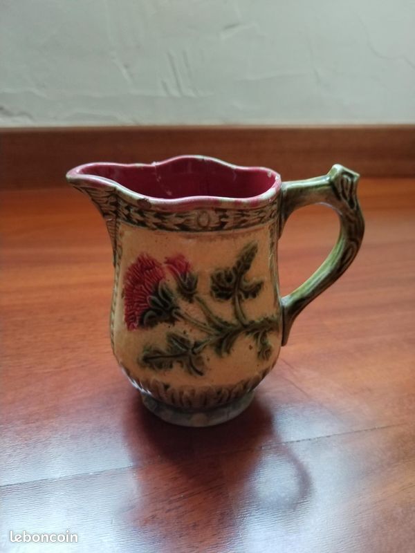 Ancien pichet en céramique barbotine vert, décor floral polychrome. Hauteur 11 cm, diamètre env. 11 x 7 cm. Bon état général, petite fissure et restauration visibles. Objet décoratif de charme (image 1)