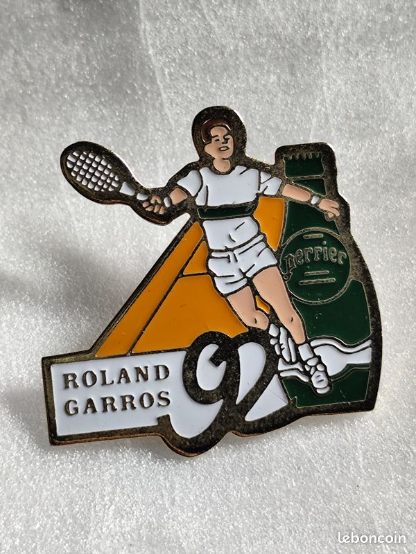 Tennis - 1 Pin's ROLAND GARROS 1992 avec pub. PERRIER, eau minérale