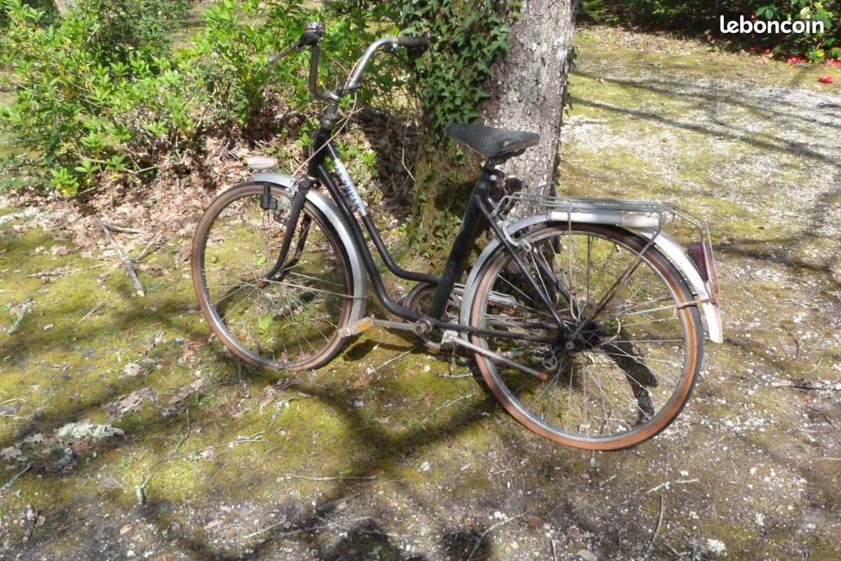 France, Femme sur un vélo devant des maisons, Vintage