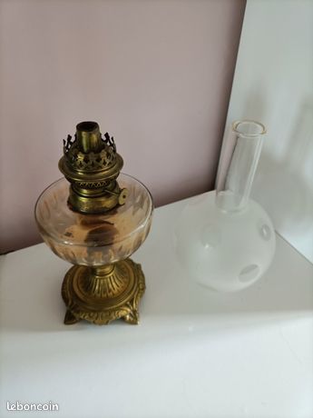 Lampe a petrole en bronze fond noir decor floral