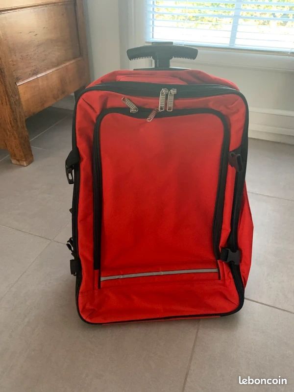 La valise souple avec roues rouge et noir qui se transforme en sac