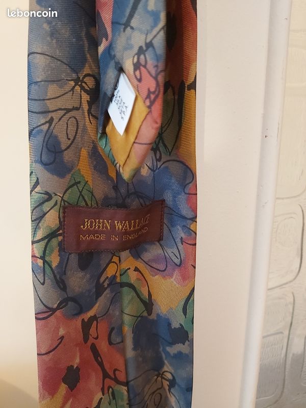 Cravate fond orange et motifs fleurs rouge bleu et feuilles vertes de marque John Wallace fabriquée en Angleterre (image 3)