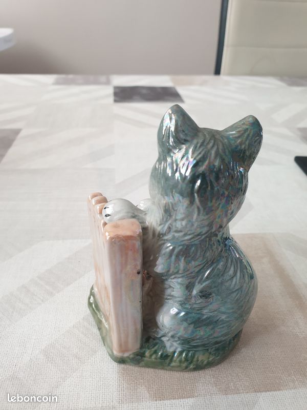 Petite figurine en céramique représentant un chat assis à côté d'une barrière (image 2)