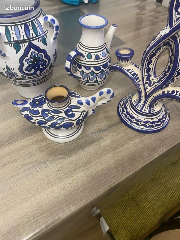 Cet ensemble de céramiques artisanales tunisiennes aux motifs traditionnels bleus et blancs se compose de divers objets décoratifs, notamment une grande jarre à anses, un petit pichet et un bougeoir s (image 1)