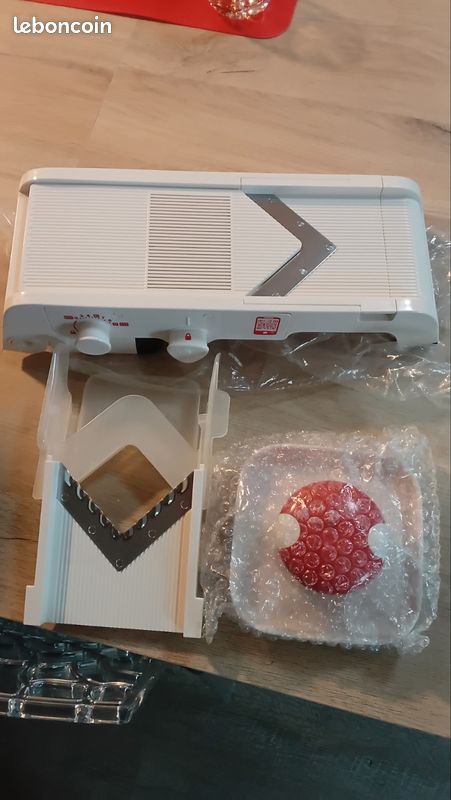 Mandoline Tupperware Mandochef Avec 2 Lames - Blanche, En Plastique. Elle Est Propre Et En Bon état, Parfaite Pour Couper Tes Légumes Facilement.