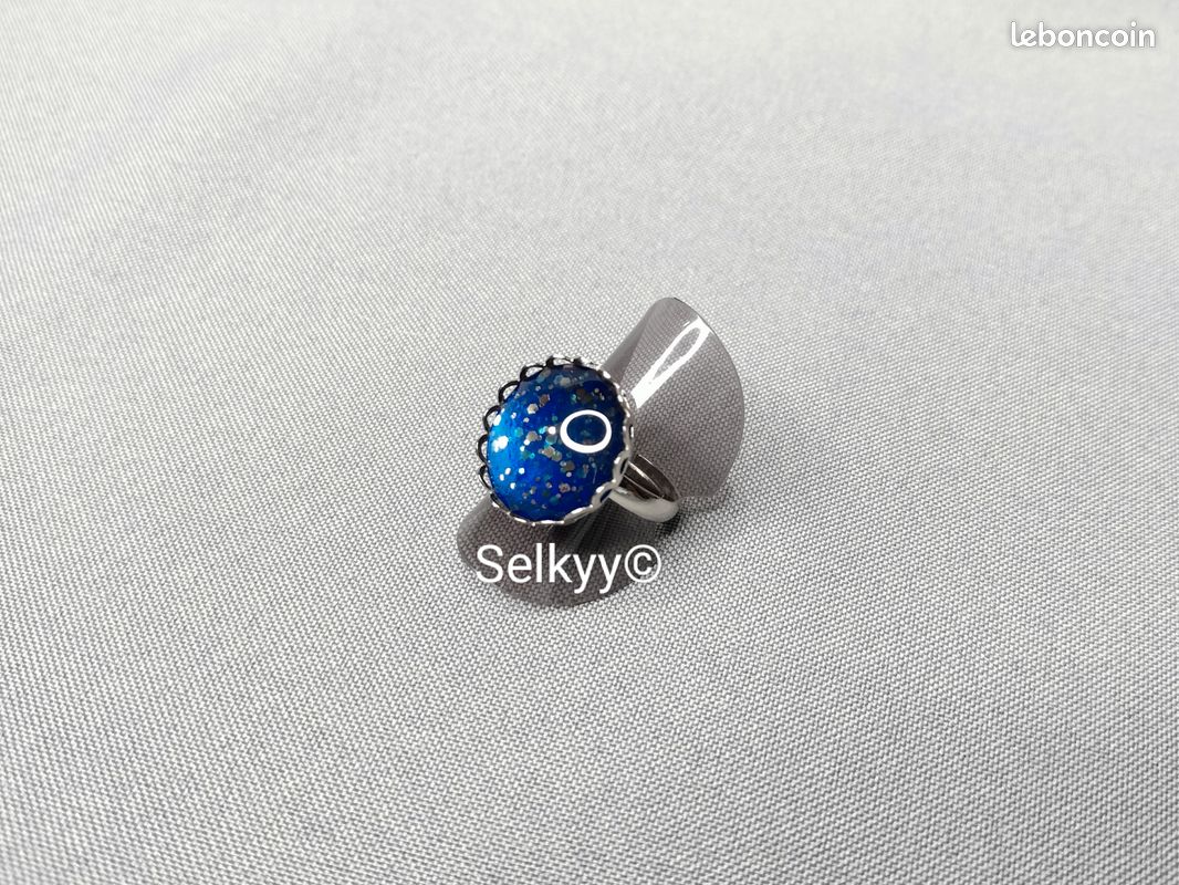 Bague fantaisie réglable en acier inoxydable ornée d’un cabochon rond bleu pailleté bleu et argent (image 1)