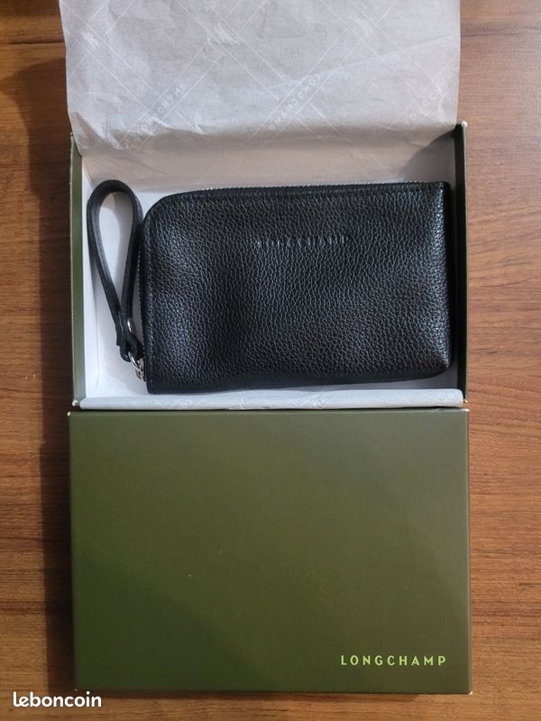 Porte carte neuf noir en cuir Longchamp
Fermé par zip, 1 compartiment intérieur.
Vendu dans sa boîte 
Neuf, jamais utilisé
Taille : 13 x 8 cm (image 1)