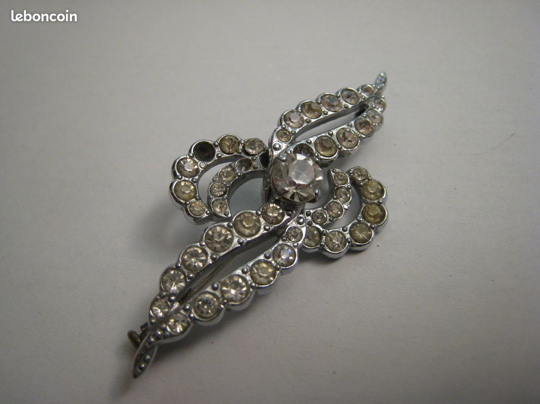 Broche vintage ancienne en métal argenté et strass motif ruban - Montres & Bijoux
